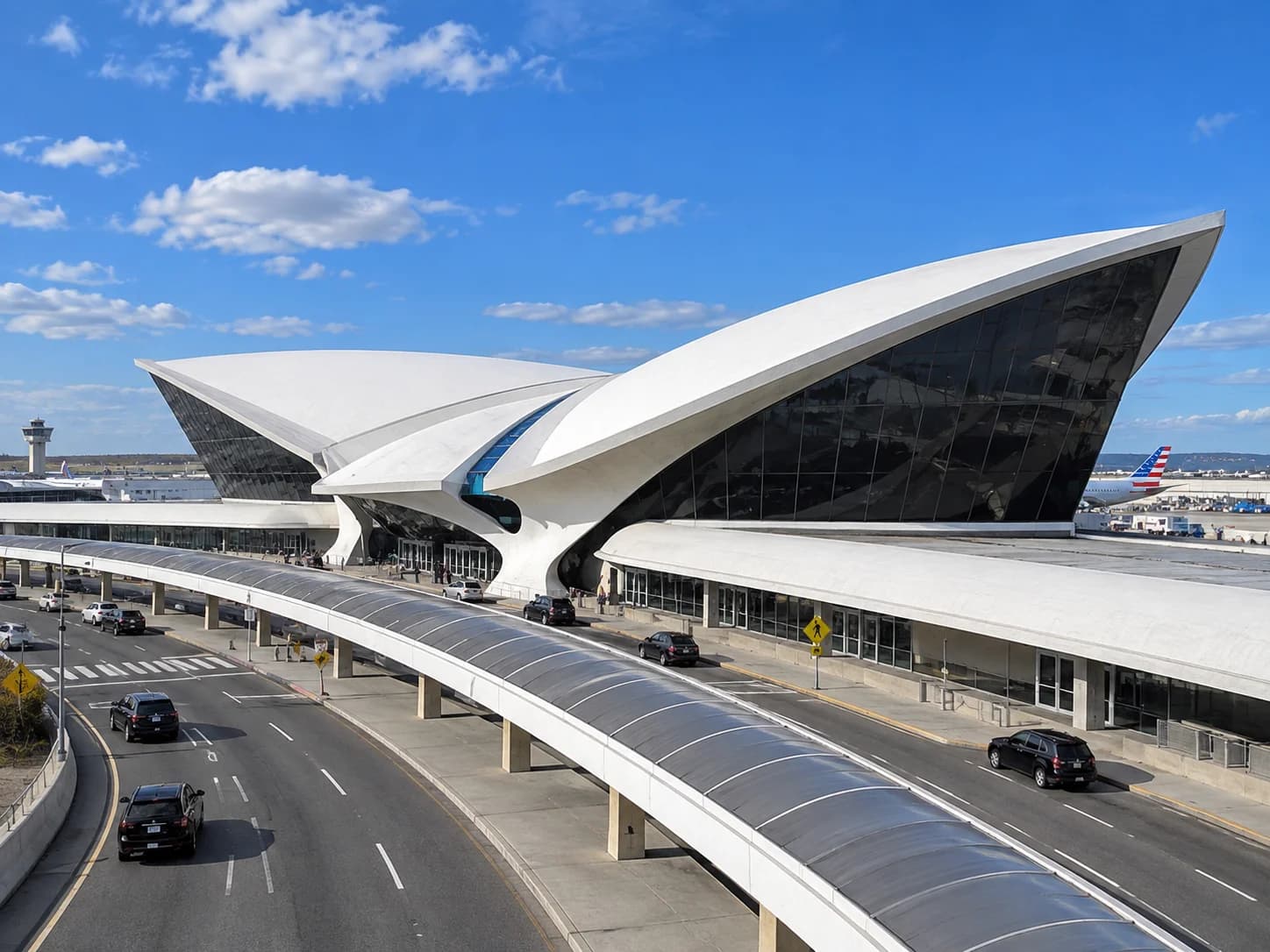 Chauffeur assisting passenger into black Escalade at JFK Airport