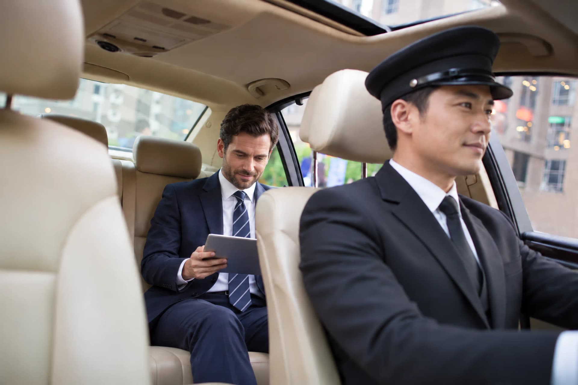 View from inside a luxury car as a man and woman in business attire exit the rear toward an office building